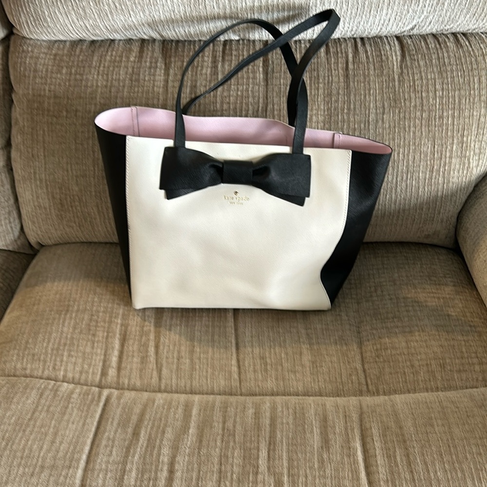 Kate Spade black and cream colored tote lined in pink approximately 16 x 12 x 5